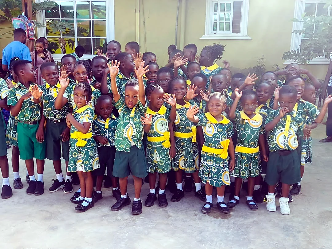 ASMA pupils smiling and waving in the school courtyard