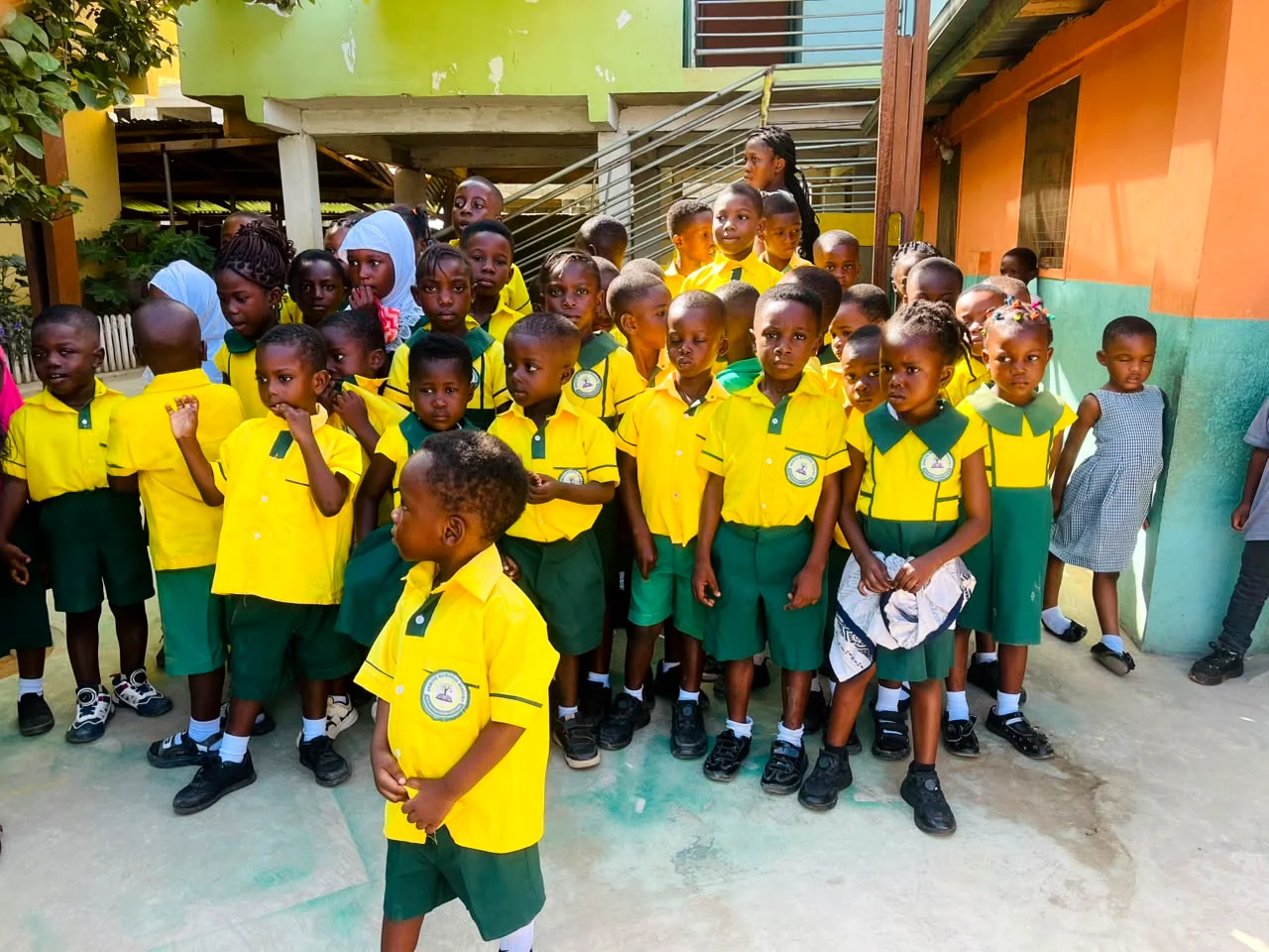 ASMA pupils gathered in the courtyard in yellow and green uniforms