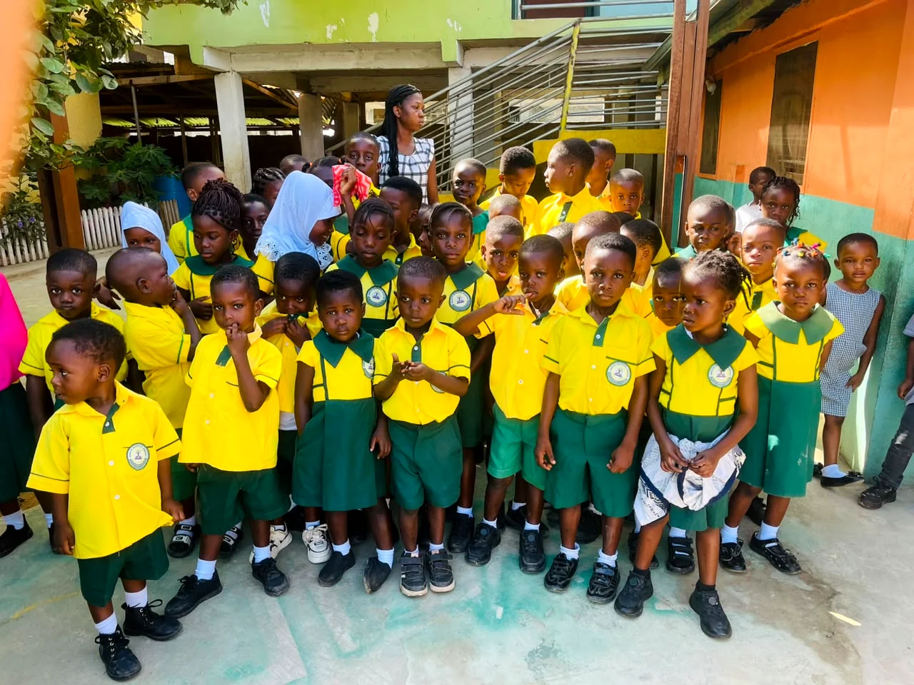 ASMA pupils in yellow and green uniforms with their teacher